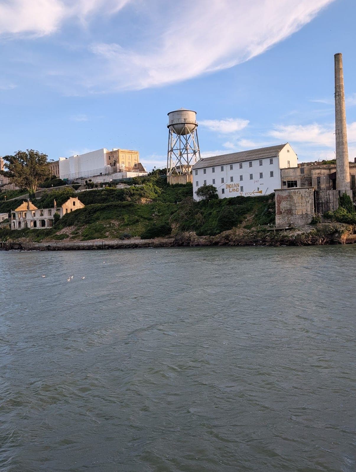 Alcatraz Island seen from the water, with its water tower and tall chimney.